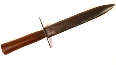 un couteau avec un manche en bois sur une surface blanche