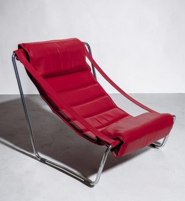 a red leather lounge chair sitting on top of a white floor