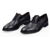 une paire de chaussures en cuir noir sur fond blanc