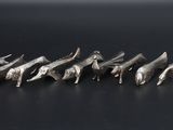 a close up of a bunch of metal birds on a black surface