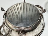 a silver plate with a lid on a white table