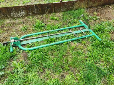 a green lawn mower laying in the grass