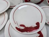 a lot of white plates with red designs on them