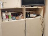 a tv on top of a cabinet in the corner of a room