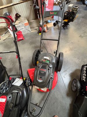 une photo d'une tondeuse à gazon et d'autres équipements de jardinage