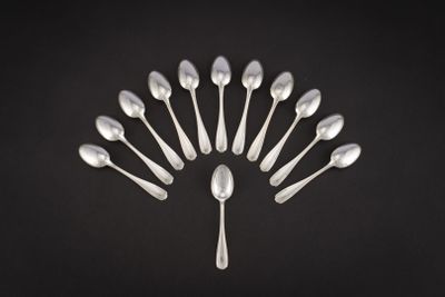 un groupe de cuillères en argent disposées en cercle sur un fond noir
