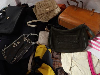 a lot of purses that are sitting on a bed