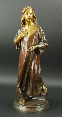 statue en bronze représentant une femme tenant ses mains dans sa main droite