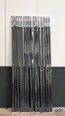 a lot of hockey sticks that are stacked on the floor
