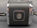 a black and silver camera with a strap on it