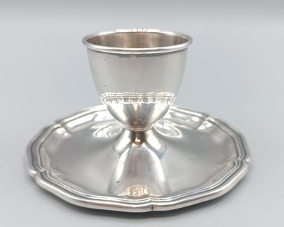 une tasse et une soucoupe en argent posées sur un plateau en argent