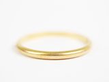 gros plan d'une bague en or sur une surface blanche