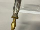 a silver and gold pen sitting on top of a white table