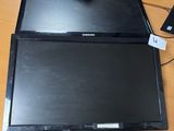 two laptops sitting on a desk next to each other