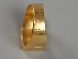 a close up of a gold ring on a white surface