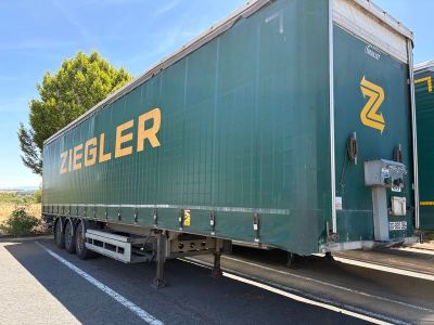 un gros camion vert garé sur le bord de la route