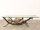 a glass and brass coffee table with birds on it