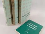 trois livres sont empilés sur une surface blanche