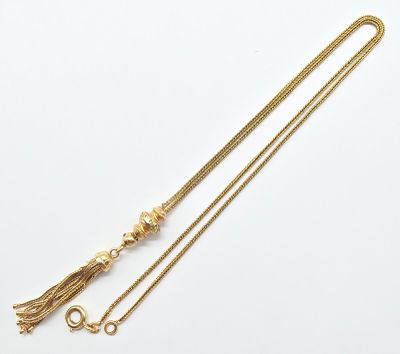 un collier en or orné d'un pompon et d'une chaîne en or