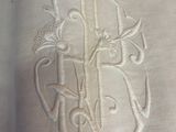 a close up of a white cloth with a monogram on it