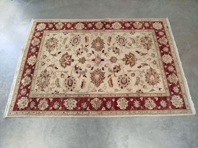 a red and white rug with a floral design on it