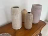 three vases that are sitting on a wooden table