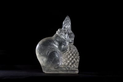a glass figurine of a cat sitting on a table