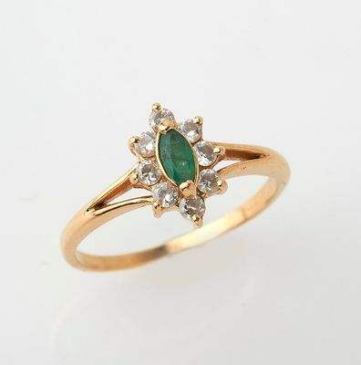 a close up of a gold ring with a green stone