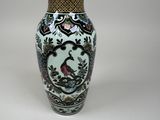 a vase with a bird on it sitting on a table
