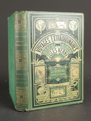 an old book with a green cover sitting on top of a table