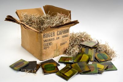 a cardboard box filled with assorted pieces of glass