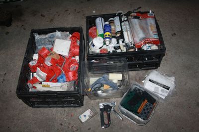 deux boîtes noires remplies d'objets divers, posées par terre