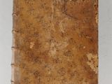 an old book sitting on top of a white surface