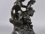an image of a bronze statue of a woman sitting on a rock