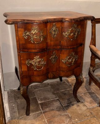 une commode en bois posée à côté d'une chaise dans une pièce
