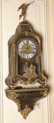 a clock hanging on the wall with a bird on top of it