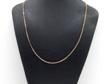 a gold chain necklace on a mannequin display