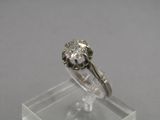 un gros plan d'une bague en diamant posée sur un socle transparent