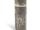 a silver vase with a design on it on a white surface