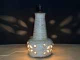 a white vase with a light on it on a table