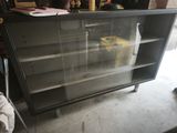 a black cabinet with a glass door in a garage