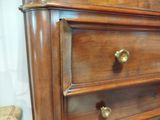 a close up of a wooden dresser with brass knobs