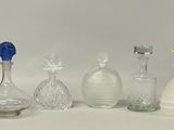 cinq vases en verre posés sur une table, sur fond blanc