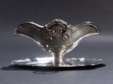 une soucoupe en argent ornée d'une tête de lion