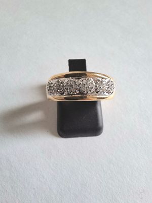 gros plan d'une bague en or ornée de trois diamants