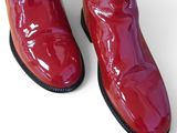 pair of red boots with black soles on a white surface