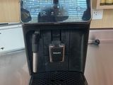 a black coffee machine sitting on a counter in a kitchen