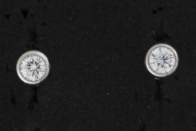 une paire de boucles d'oreilles en diamant posées sur un fond noir