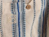 a close up of a blue and white striped shirt on a hanger