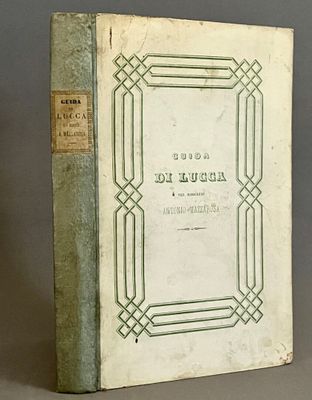 un vieux livre posé sur une table, à côté d'un vase